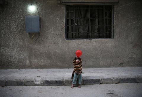 A child plays with a balloon Nov. 13, 2016, in Douma, Syria. In previous years, sanctions by the United States denied industrial parts to Syria and crippled its airline industry. (CNS/Reuters/Bassam Khabieh)